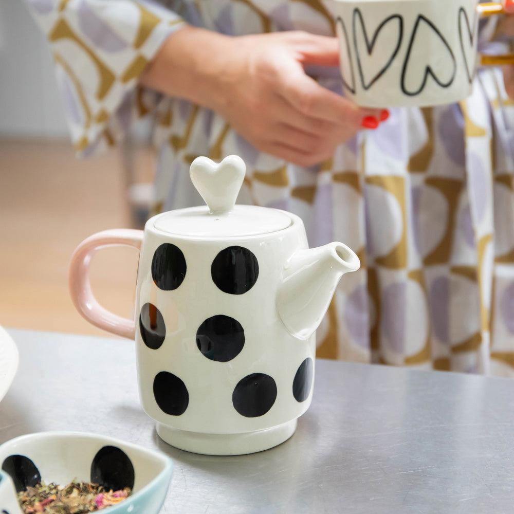 hand painted ceramic set of teapot with black dots design, pink handle and heart shaped lid and cup with heart outlines and mustard handle 