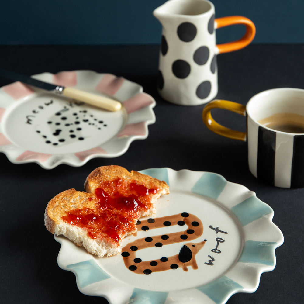 hand painted ceramic stoneware plate with light blue stripe scalloped edge, sausage dog design and 'woof' slogan