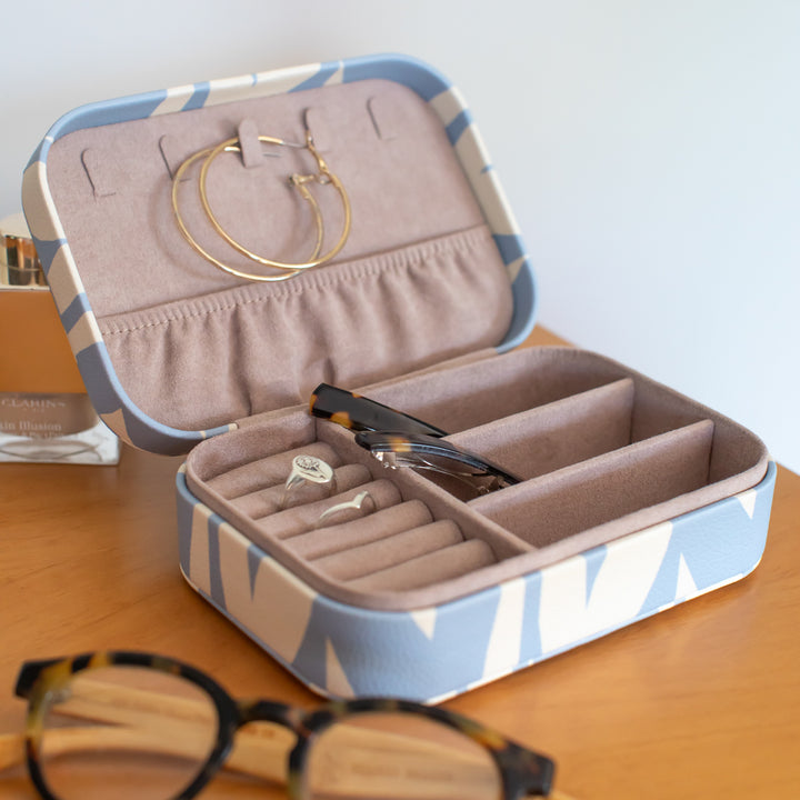 an open jewellery box with gold hoop earrings and hair slides inside on a wooden surface
