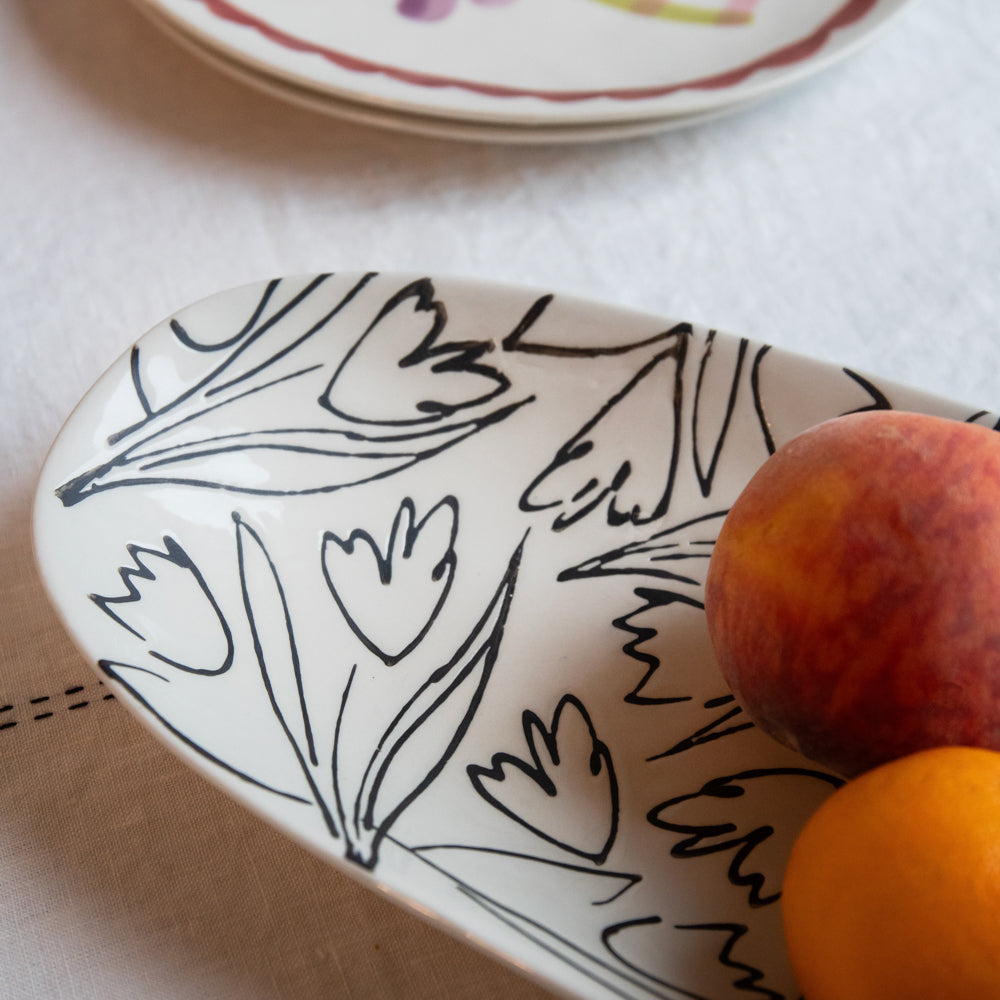 a black and white floral design serving platter with nectarines