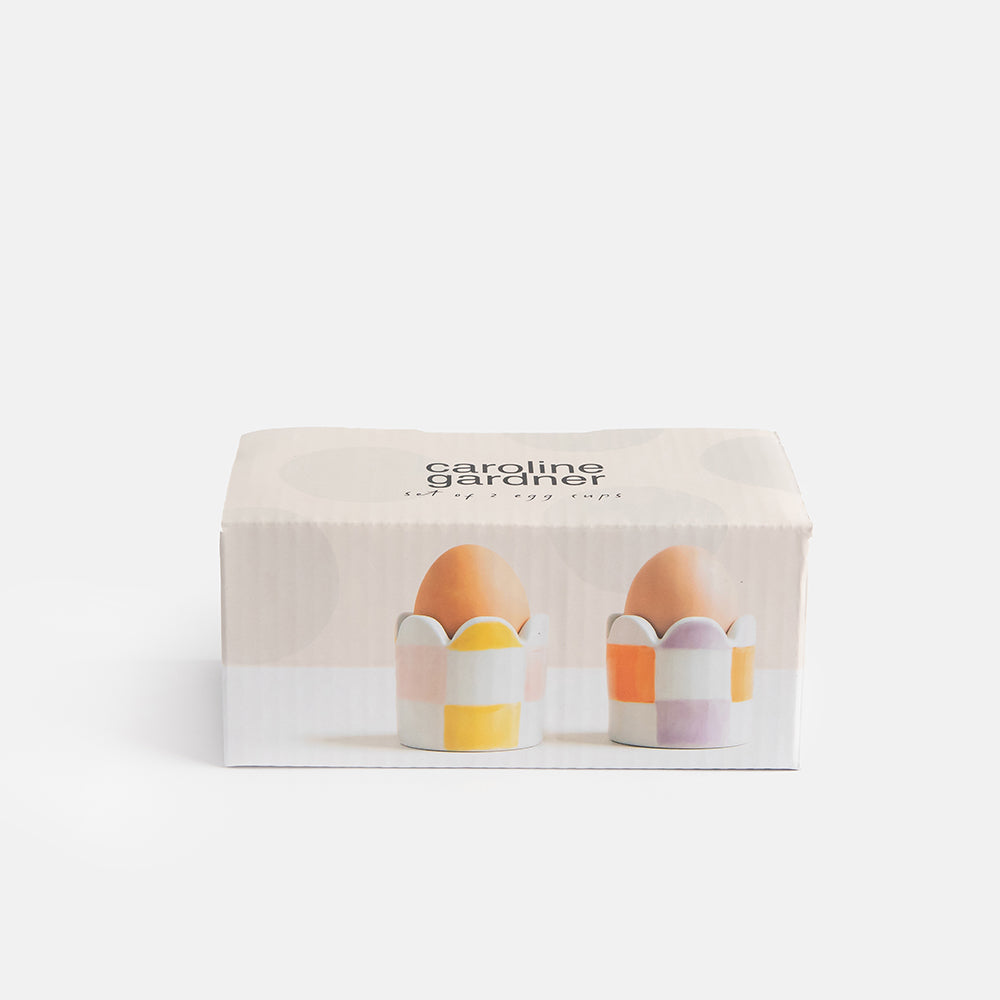 set of 2 hand painted stoneware egg cups in yellow/pink and orange/lilac check designs