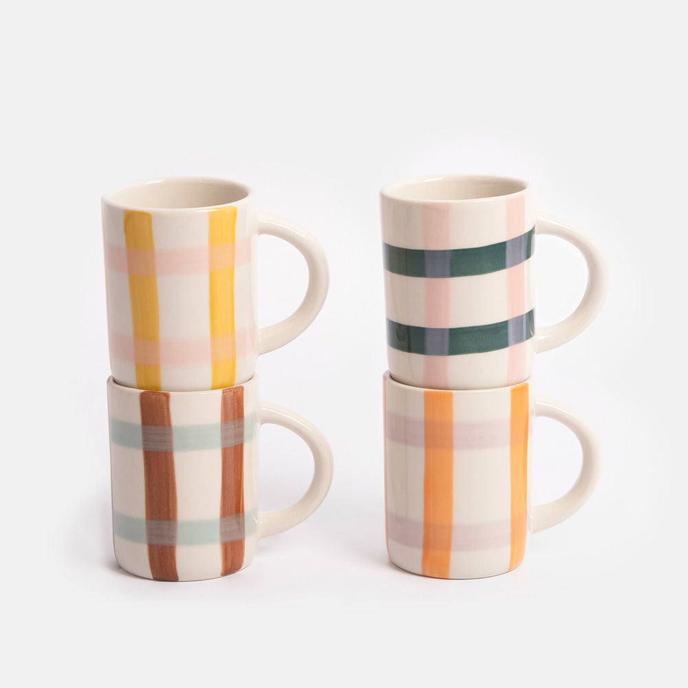 Set of four espresso cups with colourful checked patterns stacked on a white background