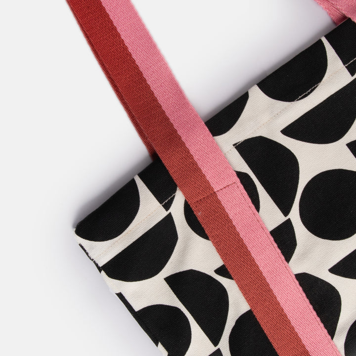 hand printed cotton canvas tote bag with monochrome geometric shapes design and colourful stripe webbing handles