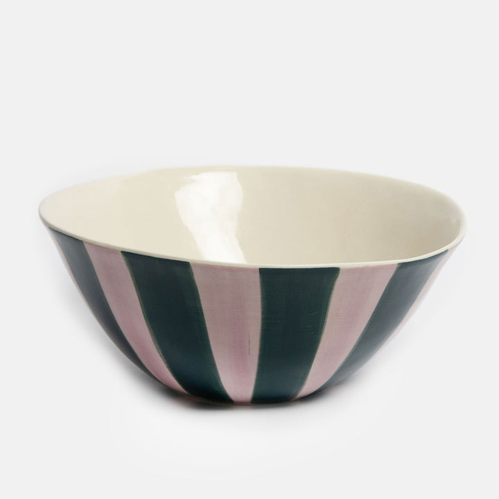A ceramic bowl with a cream-colored interior and a striped exterior featuring alternating vertical bands of dark forest green and dusty pink, set against a plain light gray background.