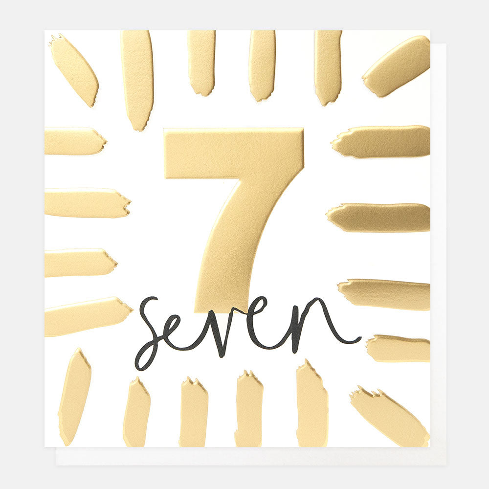 birthday card featuring the number 7 in gold foil and the word 'seven' in black handwritten style lettering
