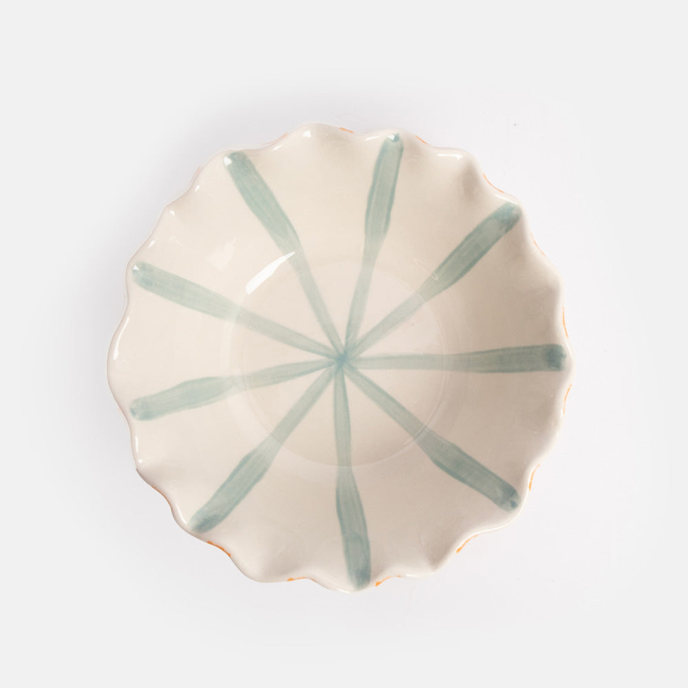 Ceramic bowl with orange stripes on the exterior, blue stripes on the interior, and a scalloped edge