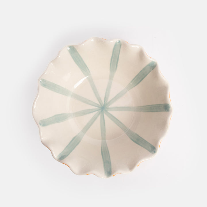 Ceramic bowl with orange stripes on the exterior, blue stripes on the interior, and a scalloped edge