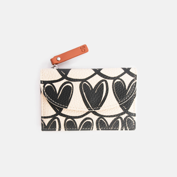 Card holder with heart pattern and brown strap on a light grey background