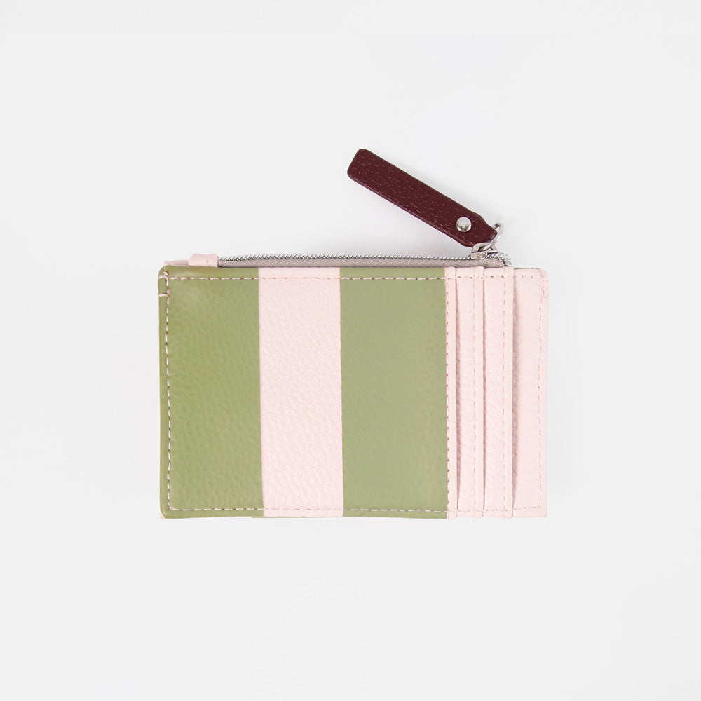 A small zippered card holder or wallet with vertical stripes in sage green and light pink, featuring a dark burgundy leather pull tab on a light gray background.