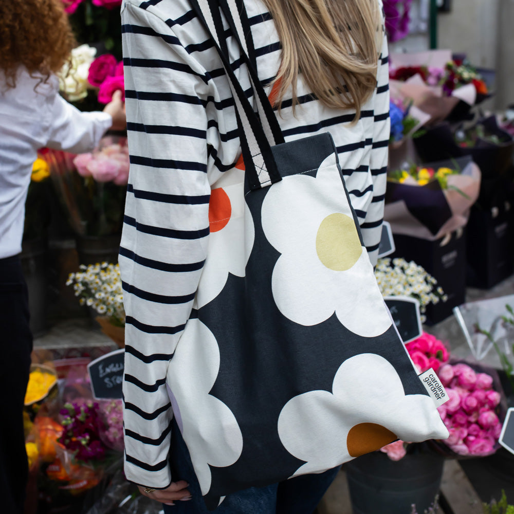 hand printed cotton canvas tote bag with colourful flowers on charcoal design and monochrome stripe webbing handles