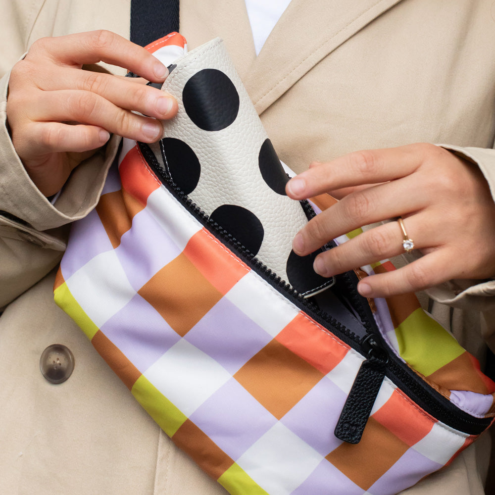 warm tones check nylon crossbody bag with black zip and straps and monochrome spot print lining