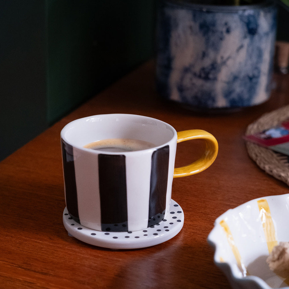 hand painted ceramic stoneware mug with black stripes design and a mustard elongated handle