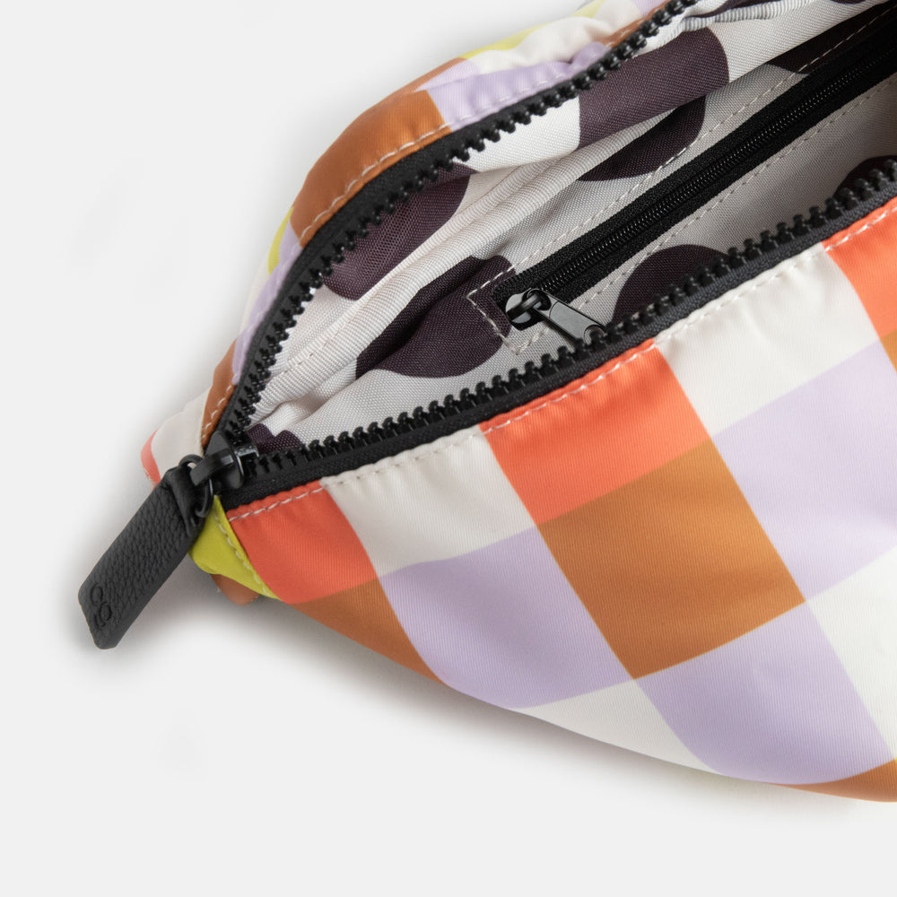warm tones check nylon crossbody bag with black zip and straps and monochrome spot print lining