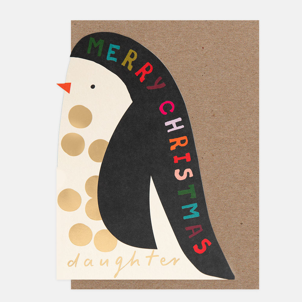 A die cut Christmas greeting card featuring a stylized penguin with a black body, cream head, gold polka dots, and a red beak. The card reads 'MERRY CHRISTMAS daughter' in colorful lettering on a brown kraft paper background.