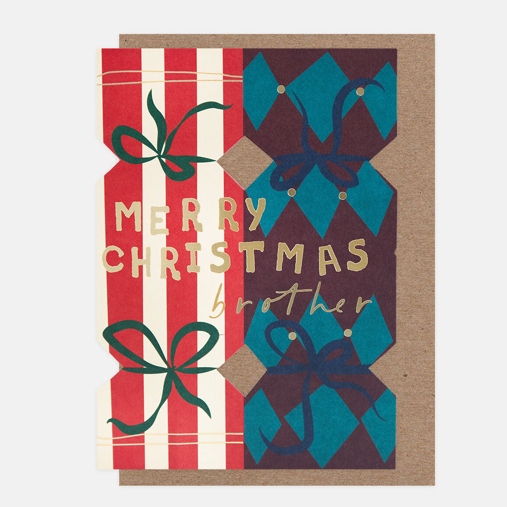 A Christmas greeting card with a kraft paper envelope, featuring die cut Christmas crackers in red and white stripes, teal and dark brown harlequin patterns, and gold foil text reading 'MERRY CHRISTMAS brother'.