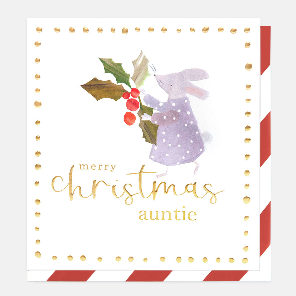 A square Christmas greeting card with a white background, featuring a watercolor illustration of a lavender bunny holding holly with red berries. The text 'merry christmas auntie' is printed in gold metallic lettering.