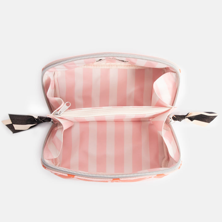 diagonal zip flat lay cosmetics bag with orange looped hearts design on pink base with pink candy striped internal lining
