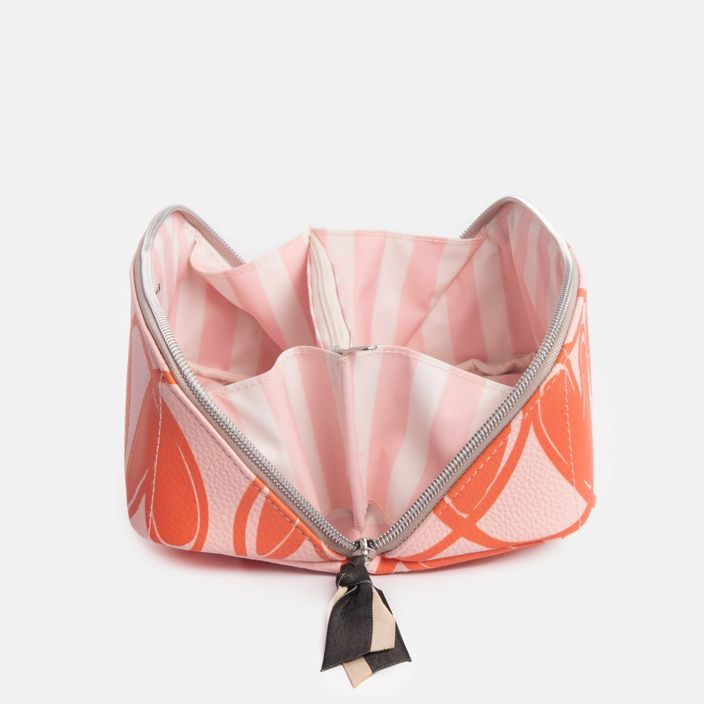 diagonal zip flat lay cosmetics bag with orange looped hearts design on pink base with pink candy striped internal lining