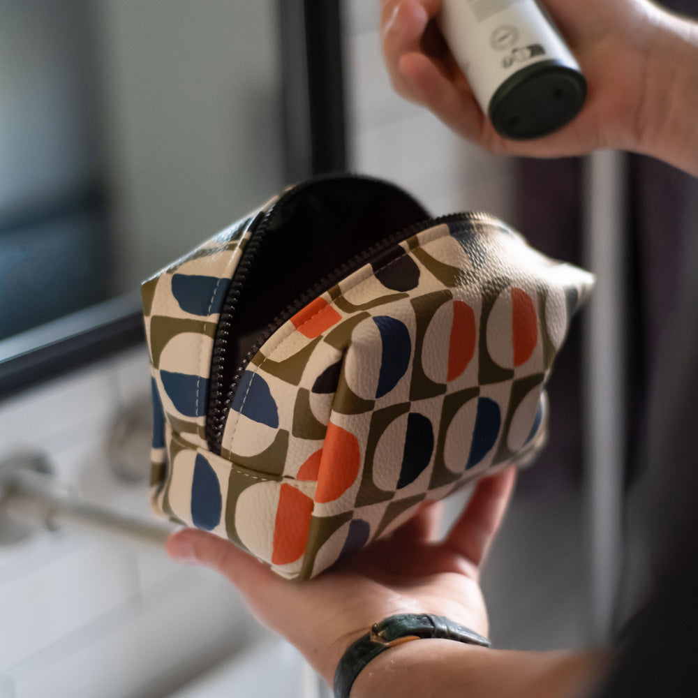 vegan leather look wash bag in green, blue, white & orange retro geometric circles print