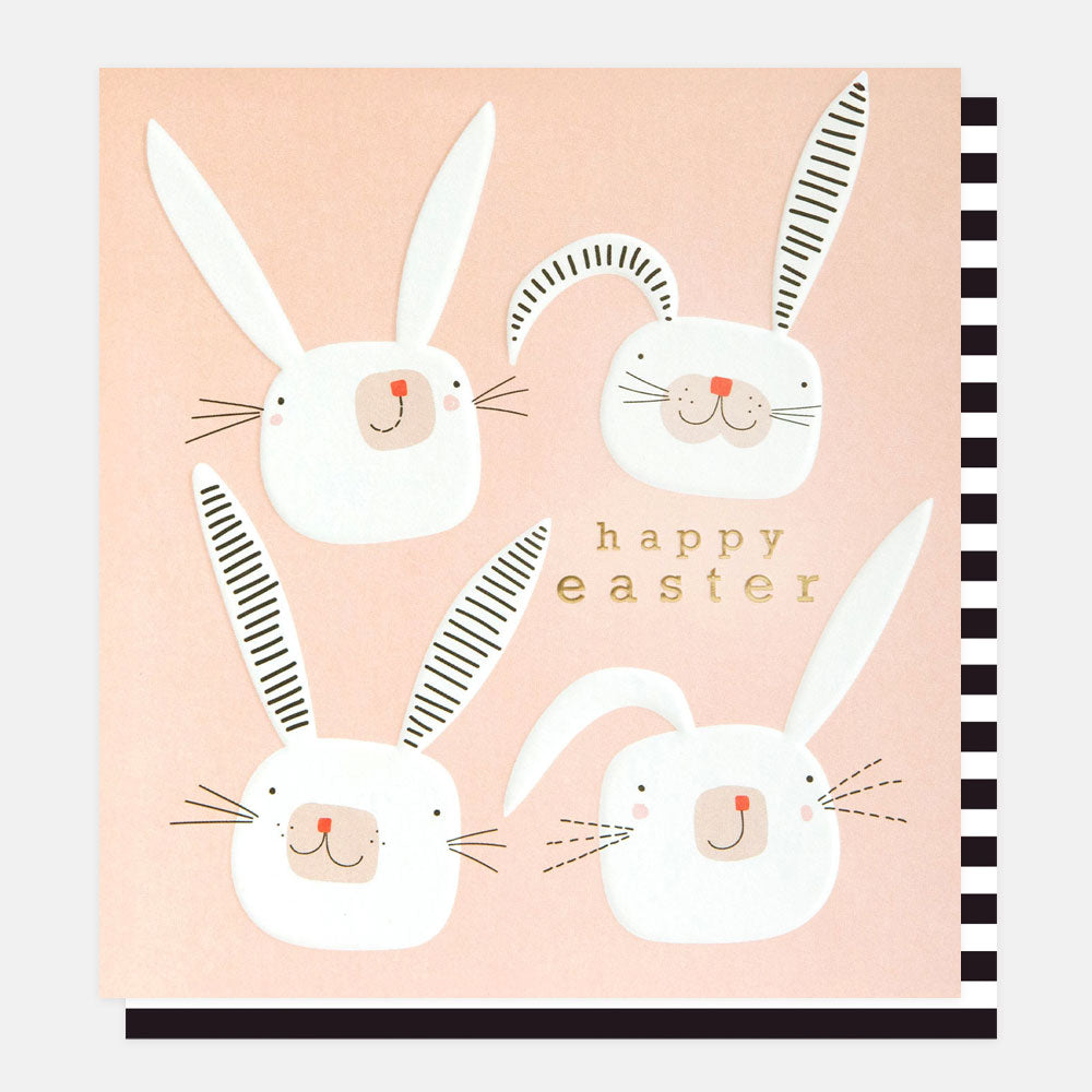 easter card featuring four hand drawn bunny rabbit faces on a pink background with the text happy easter in gold