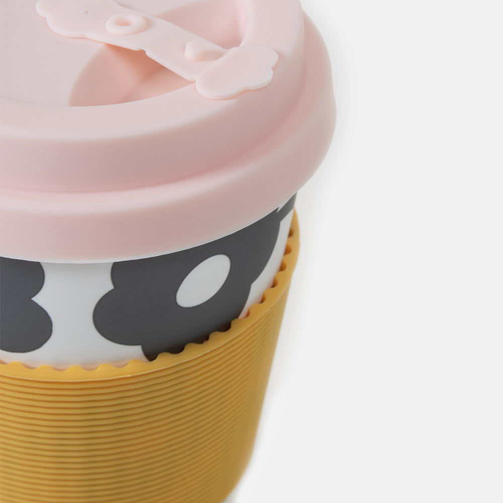 black and white floral print eco travel coffee mug with pink silicone lid and mustard yellow heat resistant band