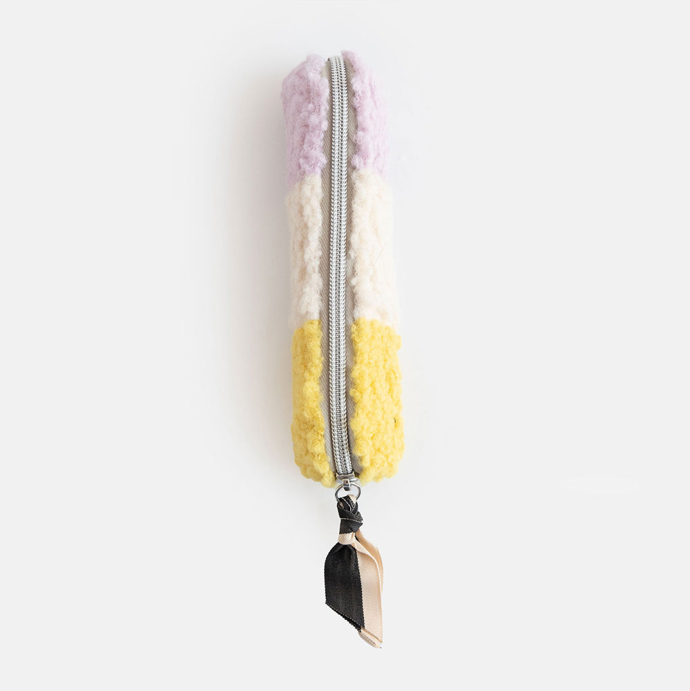 synthetic borg slim pencil case in cream, yellow and lilac with a black and white zip pull and big spots lining