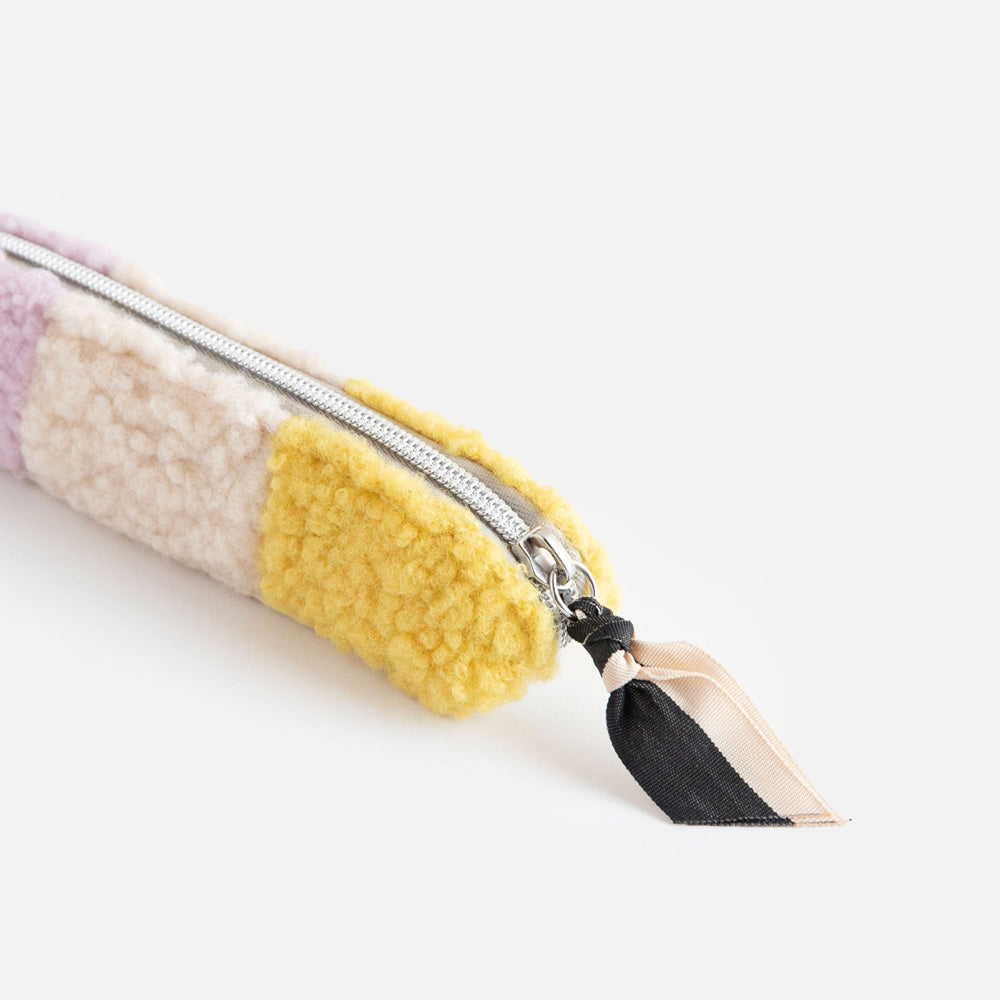 synthetic borg slim pencil case in cream, yellow and lilac with a black and white zip pull and big spots lining
