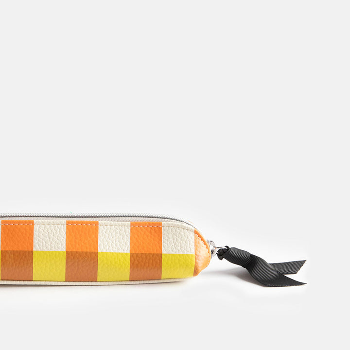 leather look PU slim pencil case in a warm tones check design with a black ribbon zip pull