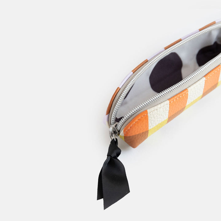 leather look PU slim pencil case in a warm tones check design with a black ribbon zip pull and big spots print lining