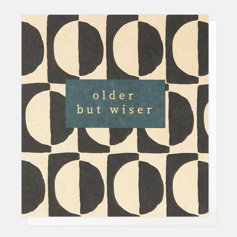 birthday card featuring a semi circles pattern in cream and black and 'older but wiser' message in gold foil
