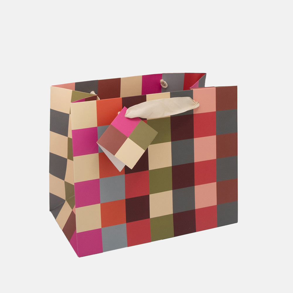 large gift bag in colourful geometric check pattern with matching gift tag and ribbon handles