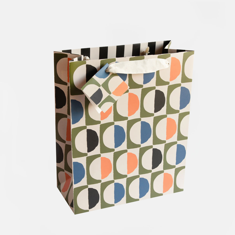 large gift bag featuring a colourful design of geometric circles and a matching gift tag