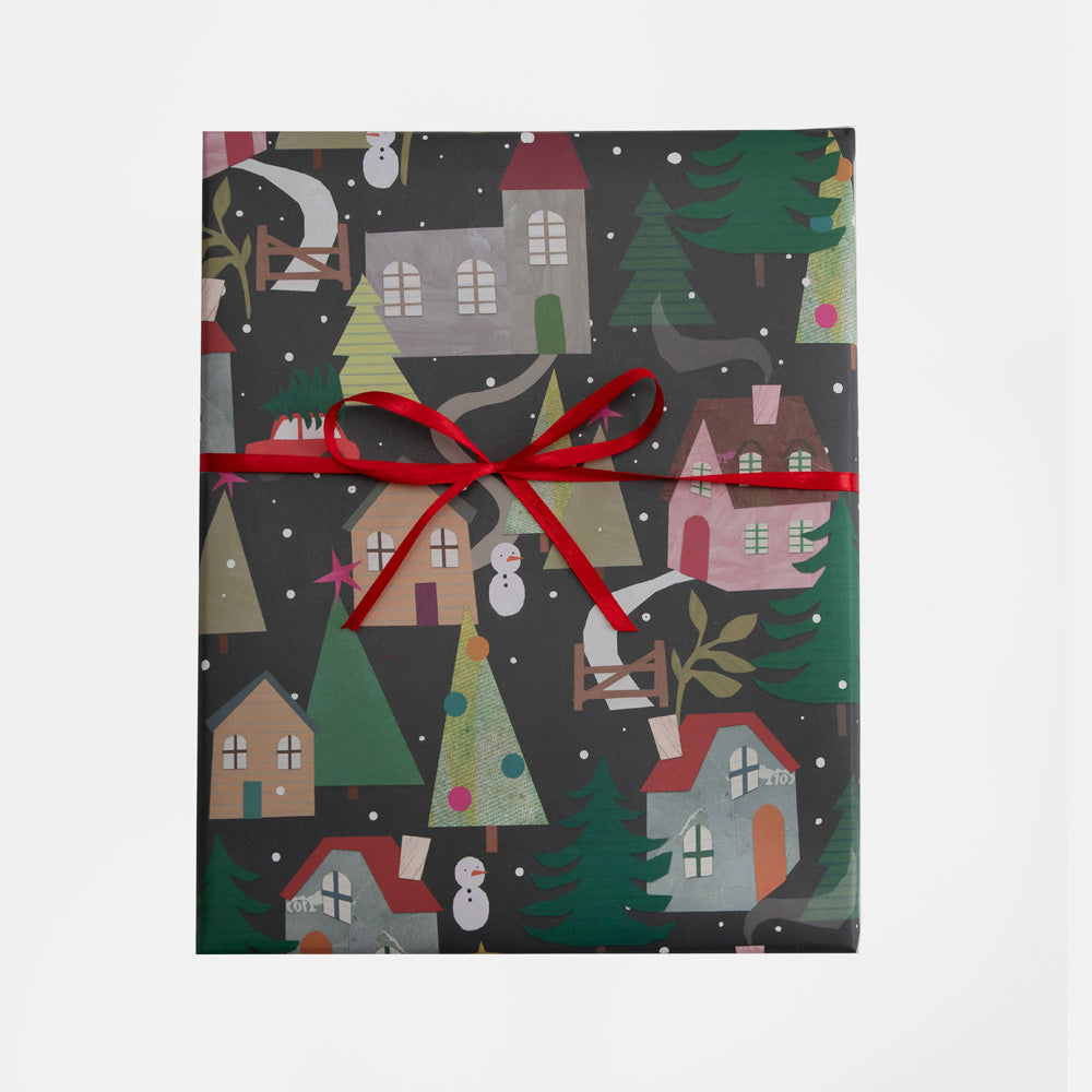 Christmas wrapping paper sheet with festive design featuring houses, trees, and a red ribbon on a white background