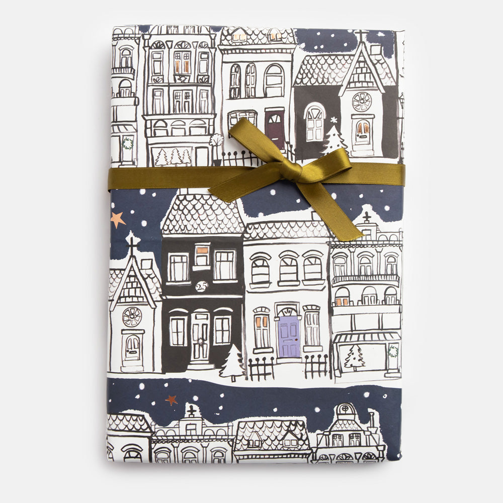 Gift wrap with black and white snowy street scene and gold ribbon 
