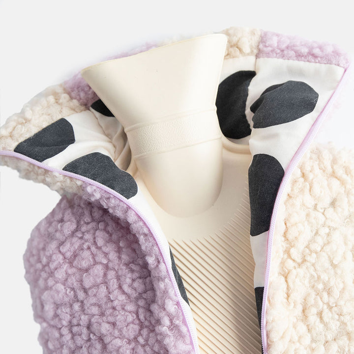 hot water bottle with a synthetic borg cover in a lilac and cream check design with a monochrome spot lining and zipped closure