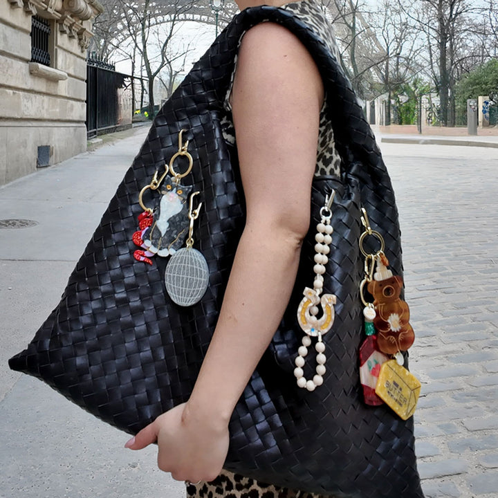 red hot sauce bag charm or keyring on black weaved leather bag