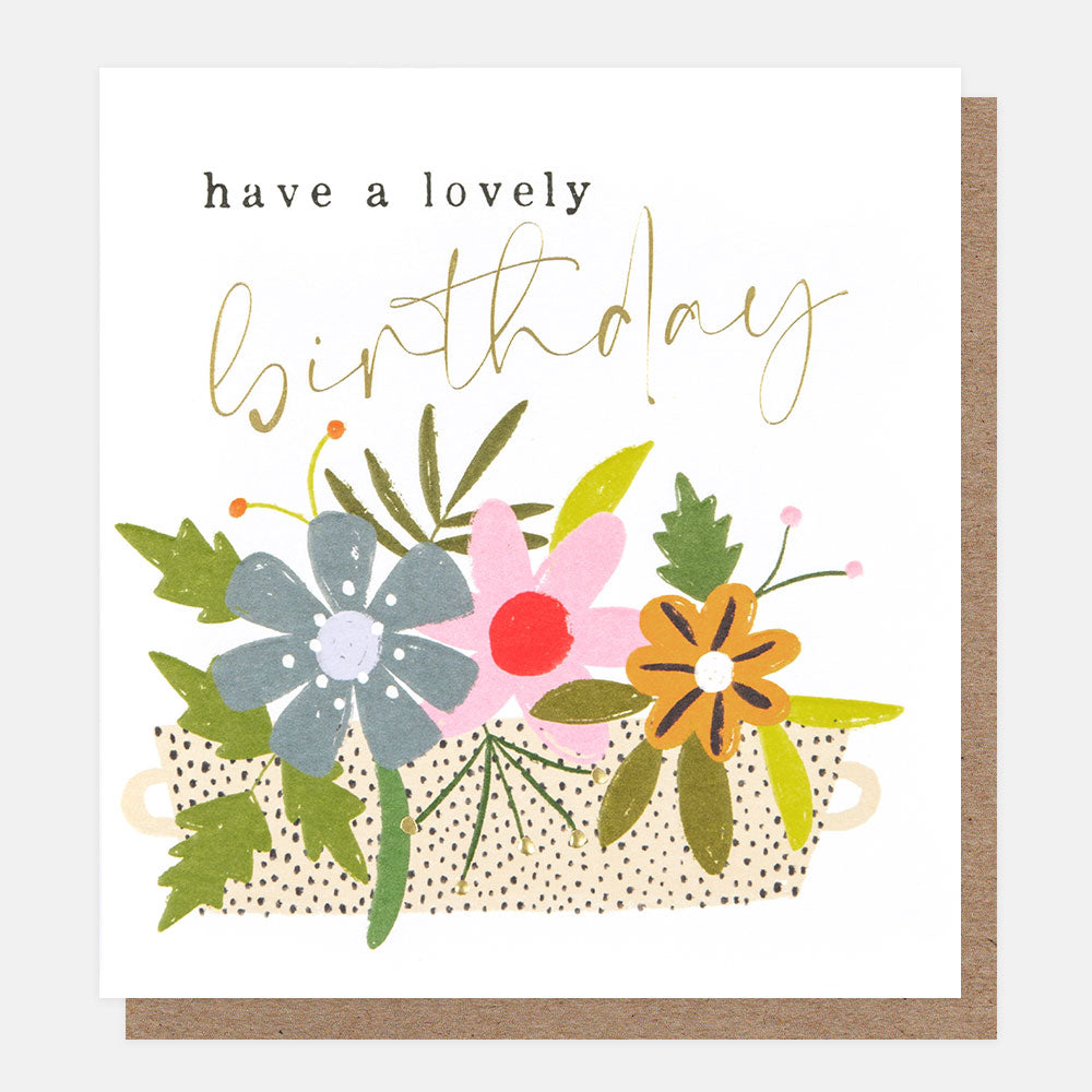 multi coloured flowers in a planter have a lovely birthday card