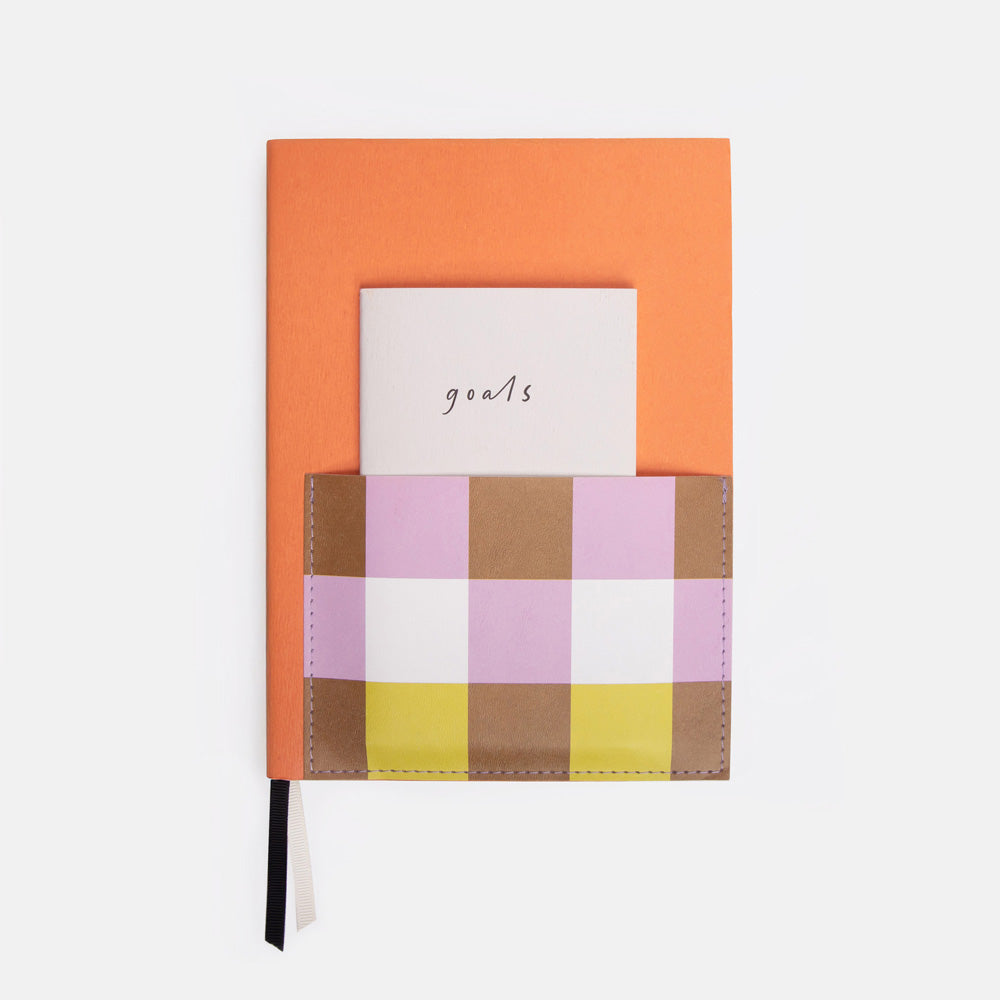 journaling set with an orange main journal with colourful front pocket containing a mini 'goals' notebook
