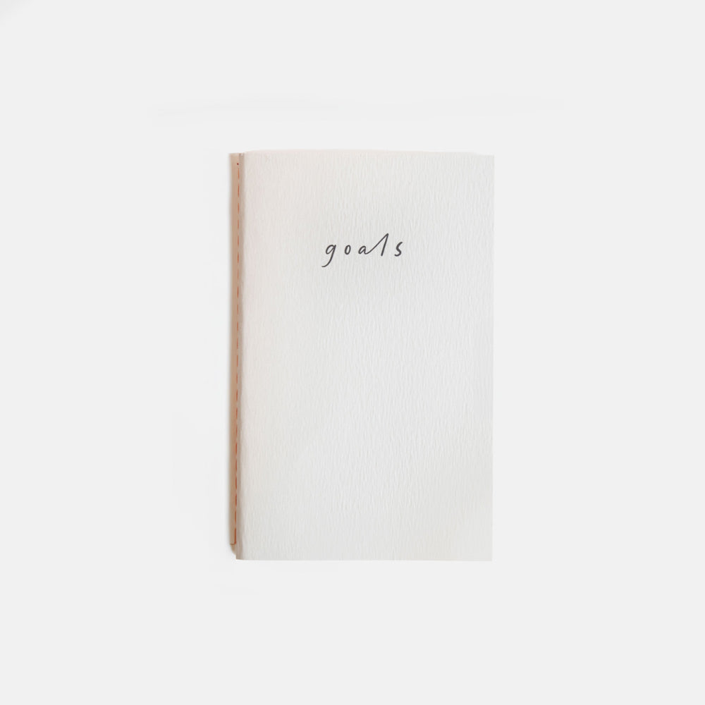 mini notebook with the word 'goals' on it