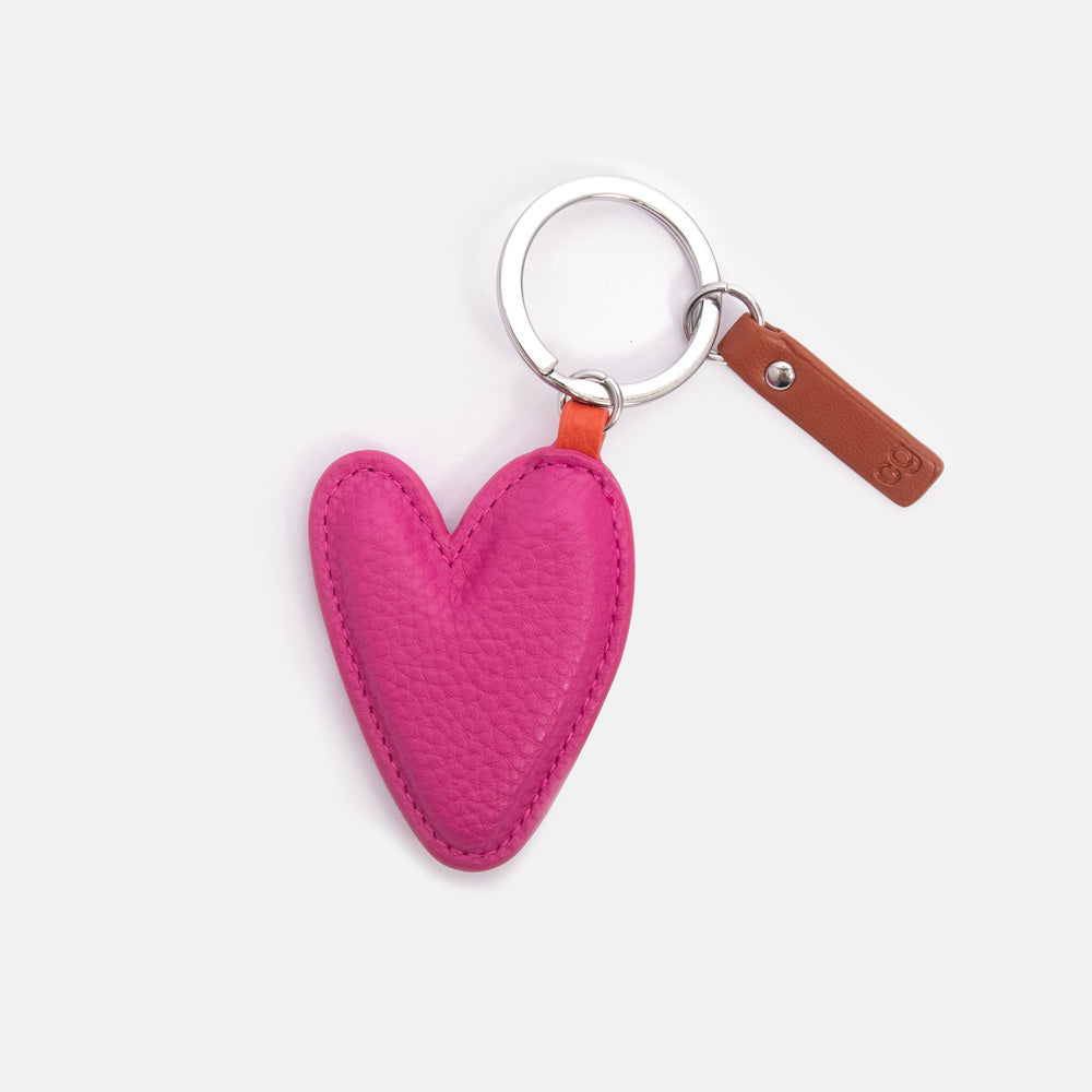 Pink heart-shaped key ring with a brown tab and silver o ring on a white background