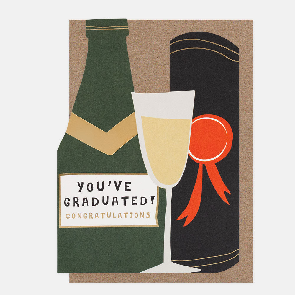die cut greetings card in the shape of a champagne bottle and flute with the text #'you've graduated! congratulations', and a brown kraft envelope