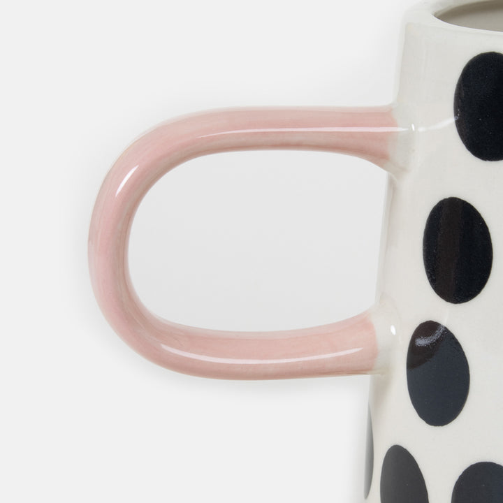 hand painted stoneware jug with black and white monochrome spot design and pale pink handle