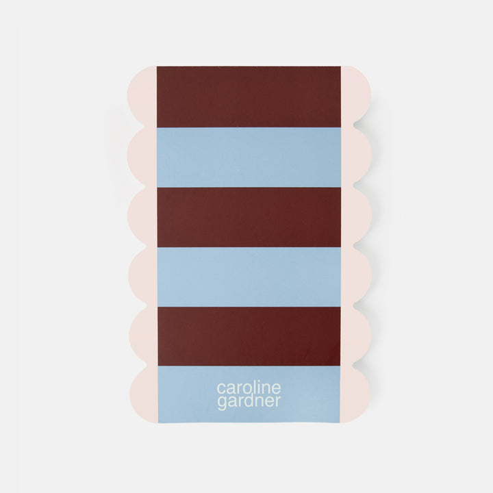 A rectangular lined list pad with scalloped edges and burgundy and light stripes on the reverse. 