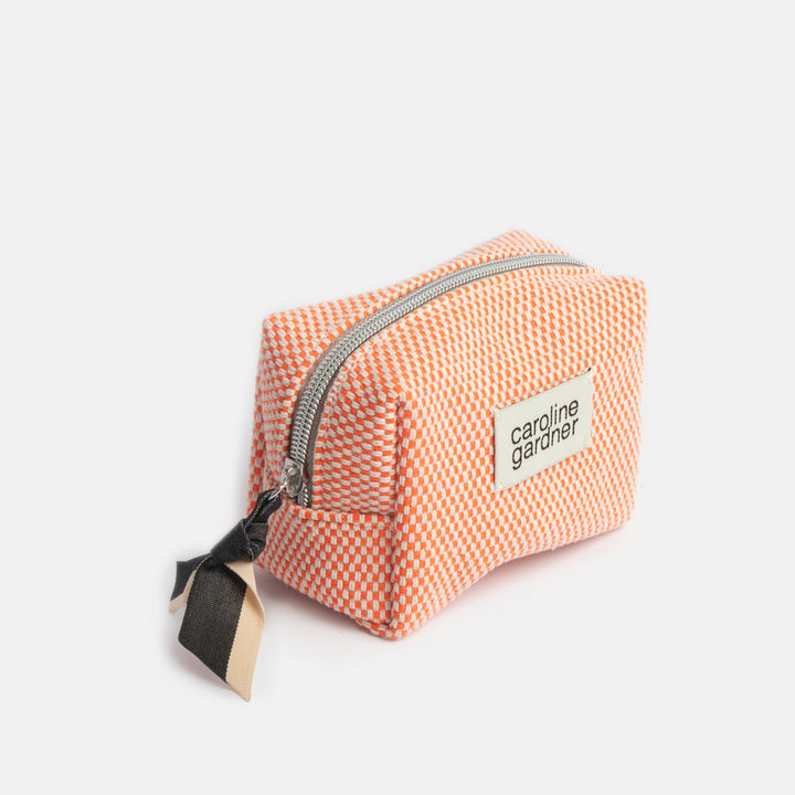 Small orange checked cosmetics bags with a black zip pull and 'caroline gardner' label on a white background