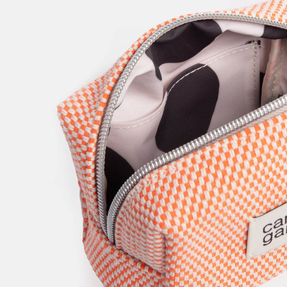 Small orange checked cosmetics bag with a black spot internal lining