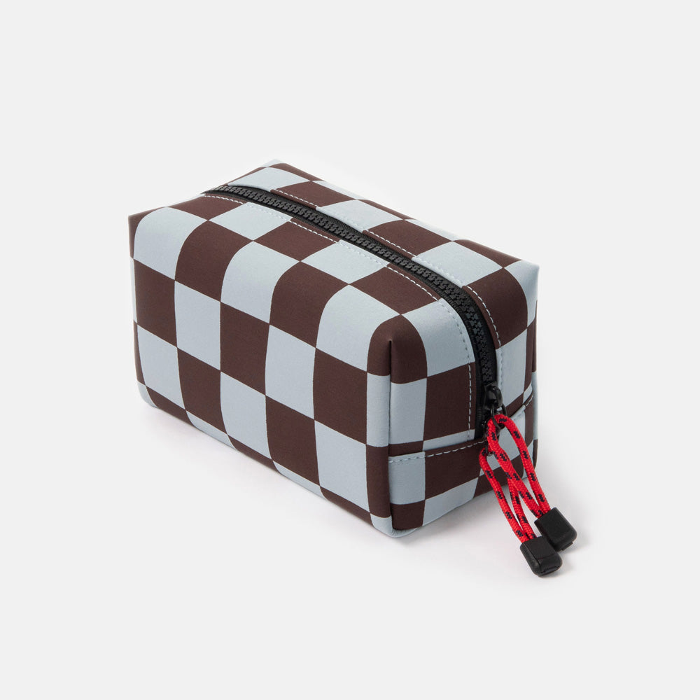 dark purple and light blue checked grooming back with black zip and red zip pulls on a white background