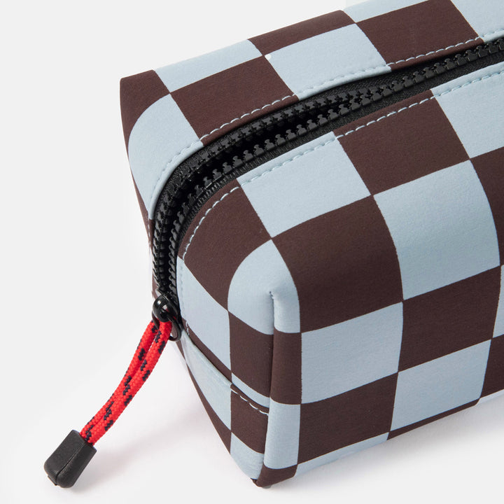 dark purple and light blue checked grooming back with black zip and red zip pulls on a white background