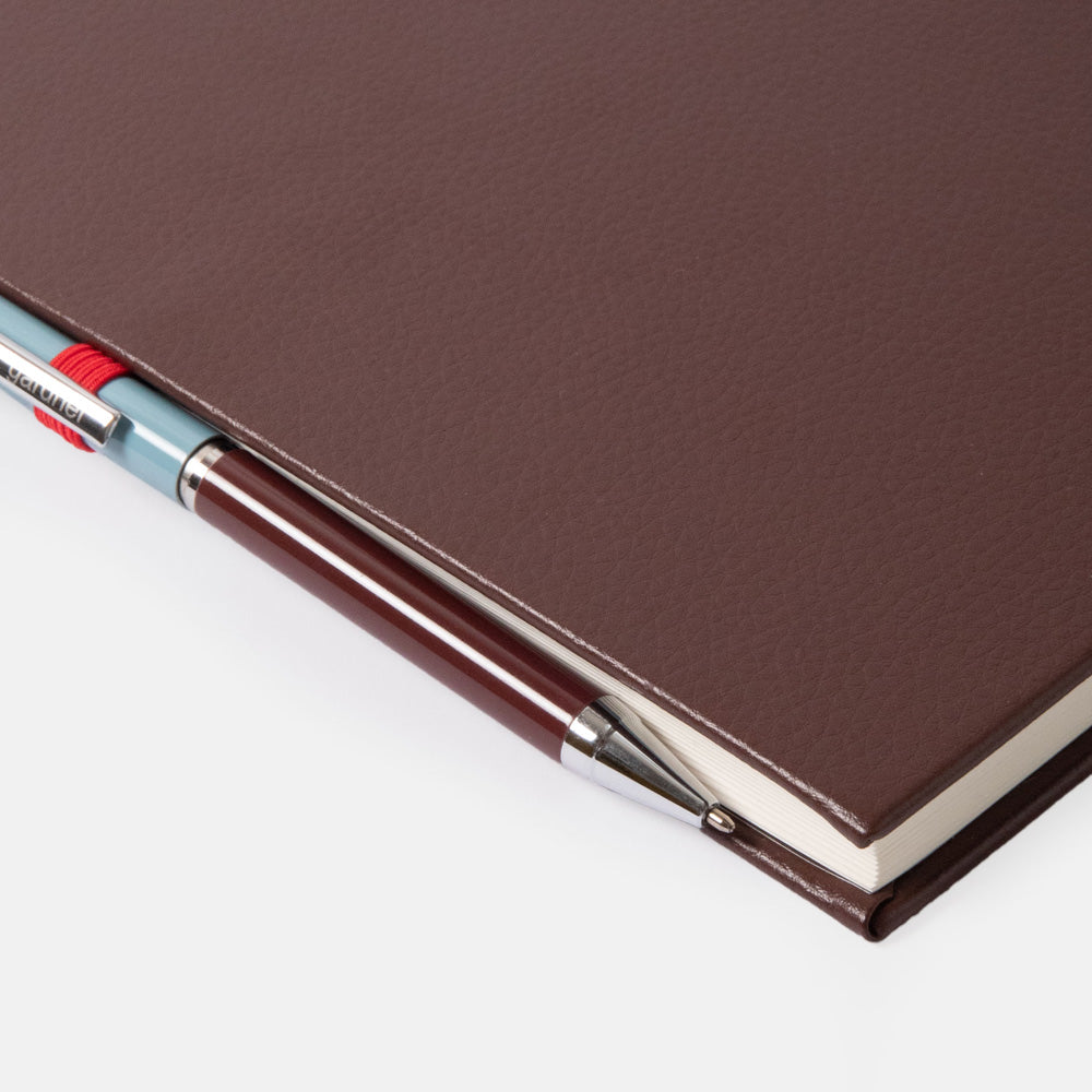 purple notebook with a pen on a white background