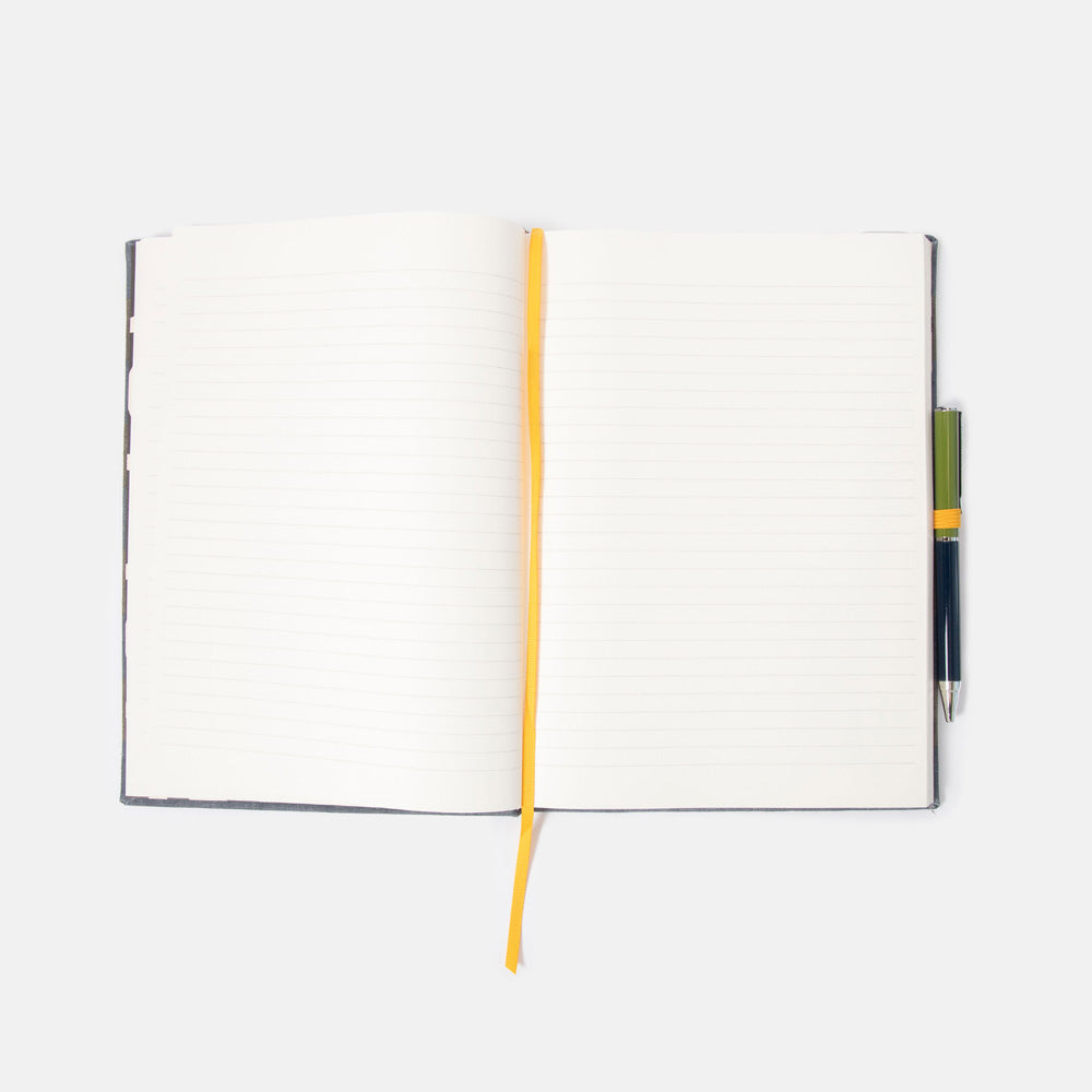 Open lined notebook with a pen on a white background