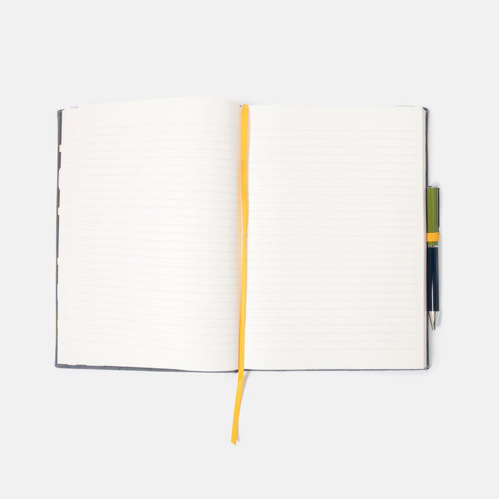 Open lined notebook with a pen on a white background